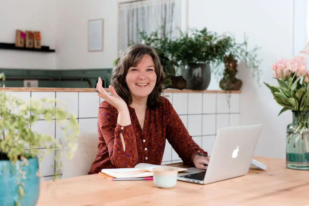 Design Dojo, Bea Faling zwaait naar je vanachter een bureau met laptop